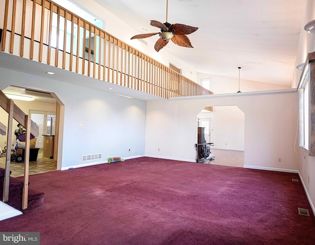 unfurnished living room with arched walkways, visible vents, and a ceiling fan