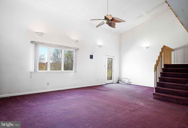 unfurnished living room with carpet floors, stairs, ceiling fan, and high vaulted ceiling
