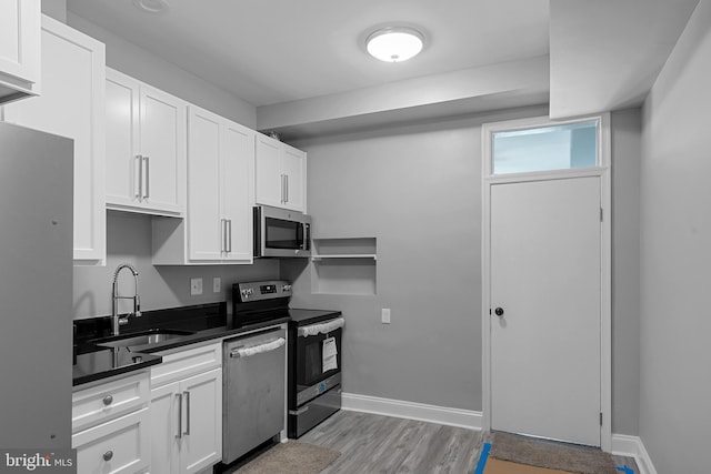 3417 Edmondson Ave, Baltimore, MD 21229 - kitchen featuring dark countertops, a sink, white cabinetry, and appliances with stainless steel finishes