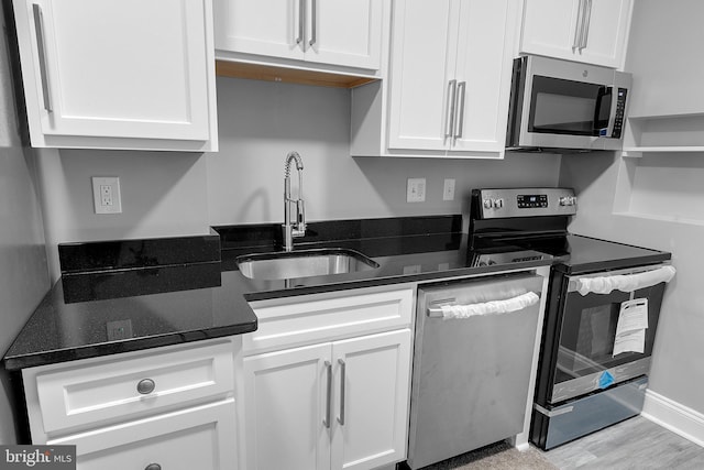 3417 Edmondson Ave, Baltimore, MD 21229 - kitchen with stainless steel appliances, a sink, white cabinetry, and dark stone counters