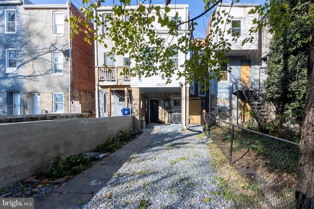 3417 Edmondson Ave, Baltimore, MD 21229 - view of front facade featuring a carport, driveway, fence private yard, and stairs
