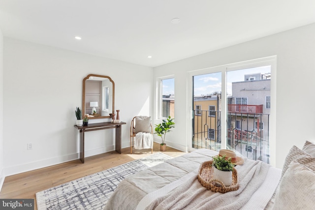 bedroom with access to exterior, recessed lighting, wood finished floors, and baseboards