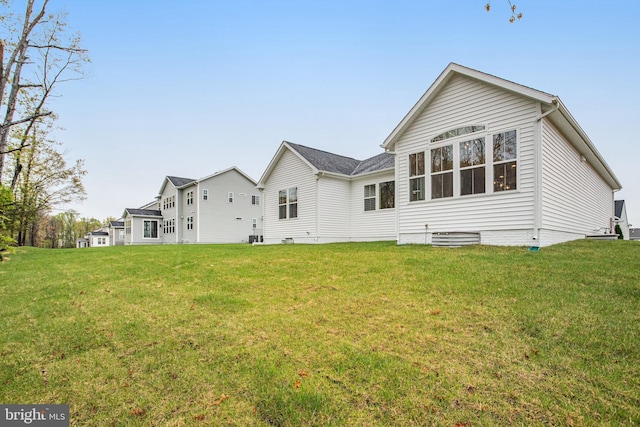 back of house with crawl space and a lawn