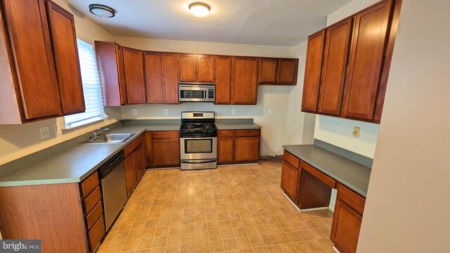 5502 Frankford Estates Dr, Baltimore, MD 21206 - kitchen with brown cabinetry, built in desk, appliances with stainless steel finishes, and a sink