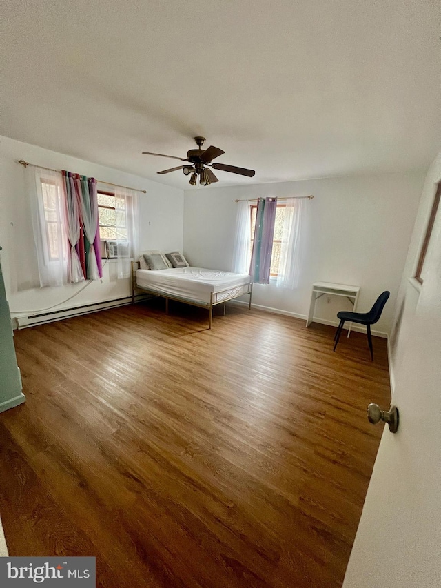 1076 Lancaster Dr, Bushkill, PA 18324 - unfurnished bedroom with a ceiling fan, cooling unit, a baseboard heating unit, and wood finished floors
