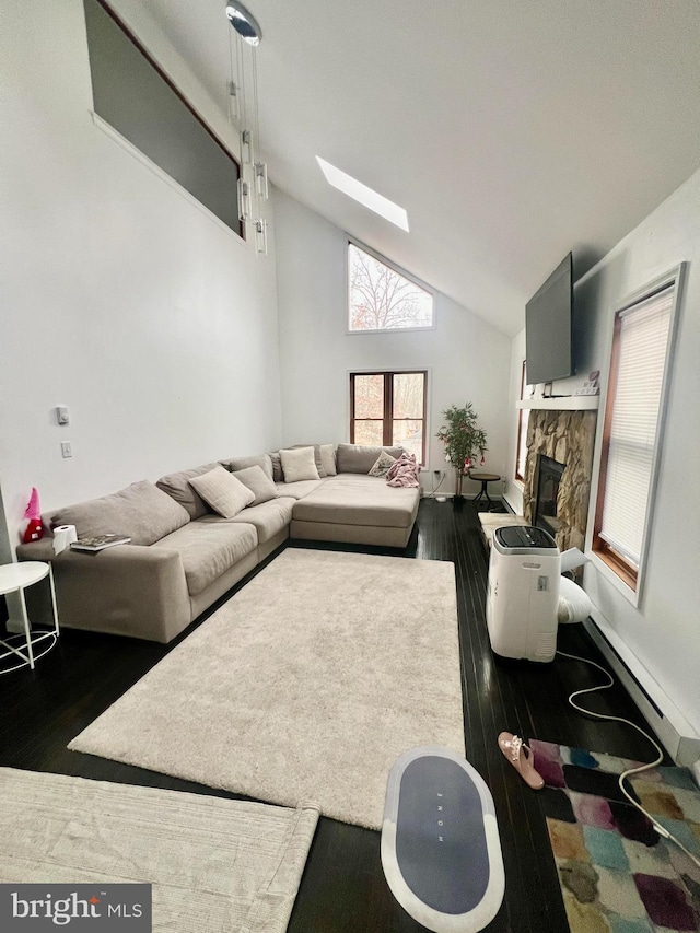 1076 Lancaster Dr, Bushkill, PA 18324 - living room featuring a stone fireplace, a baseboard radiator, wood finished floors, a skylight, and high vaulted ceiling