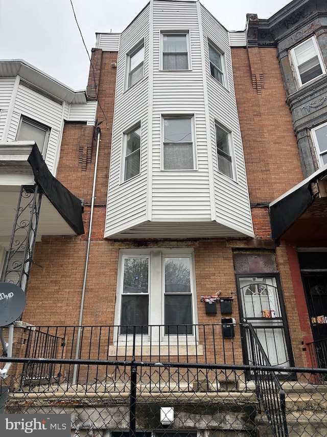 view of home's exterior featuring brick siding and fence