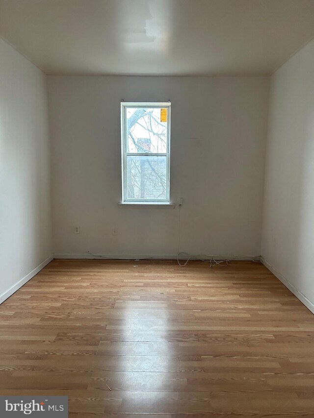 unfurnished room with light wood-style floors and baseboards