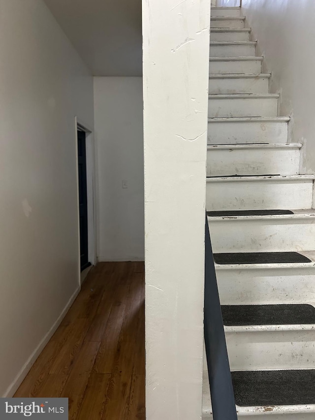 stairs featuring baseboards and wood finished floors