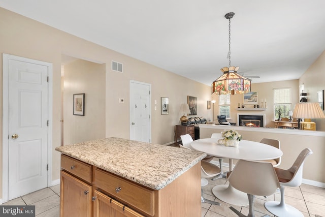 822 Rhinehart Ln, Phoenixville, PA 19460 - kitchen with a lit fireplace, open floor plan, light tile patterned flooring, and a center island