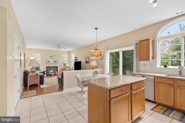 822 Rhinehart Ln, Phoenixville, PA 19460 - kitchen featuring a sink, light tile patterned flooring, a glass covered fireplace, stainless steel dishwasher, and tasteful backsplash