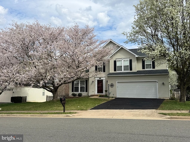 traditional-style home featuring an attached garage, driveway, and a front lawn