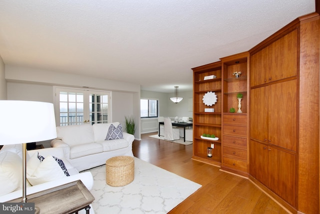 living room with light wood-type flooring and a textured ceiling