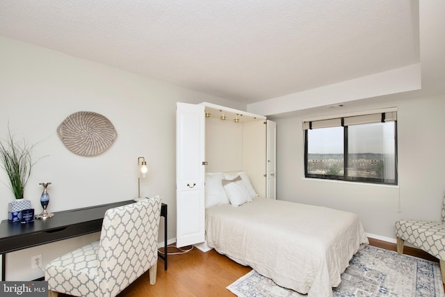 bedroom featuring baseboards and wood finished floors