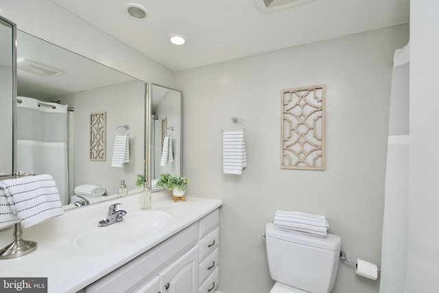 full bath featuring vanity, a shower with shower curtain, toilet, and visible vents