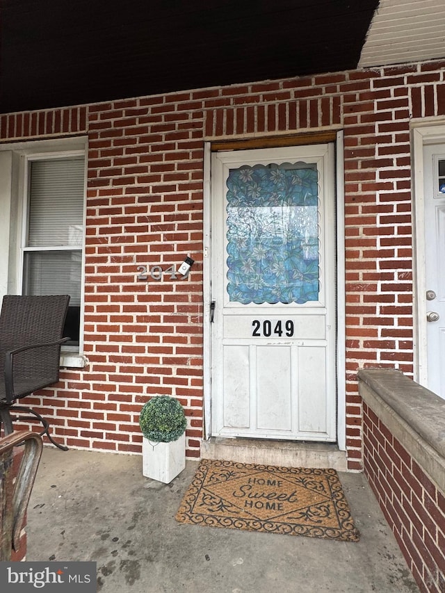 entrance to property featuring brick siding