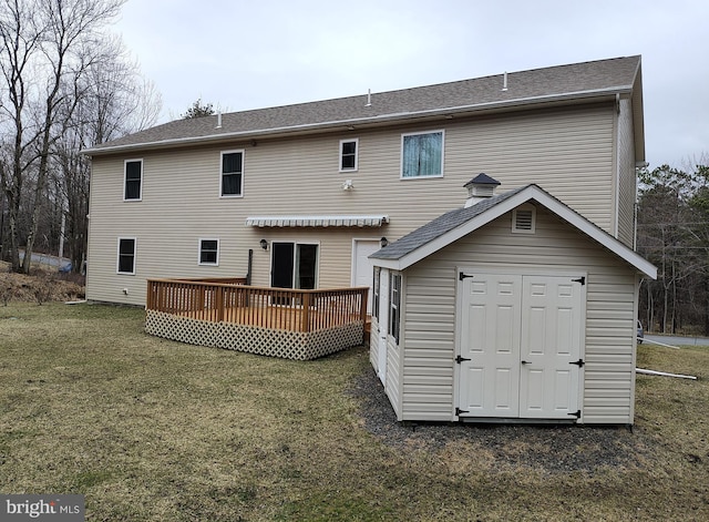 back of house with a yard, a deck, a storage shed, and an outbuilding