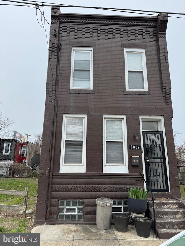 view of front facade with entry steps and brick siding