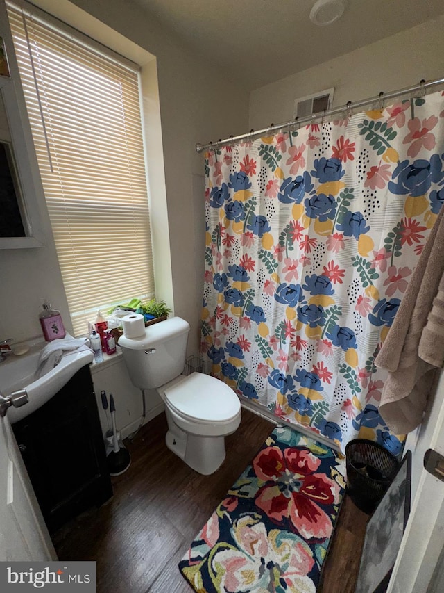 full bathroom featuring vanity, visible vents, wood finished floors, toilet, and a shower with shower curtain