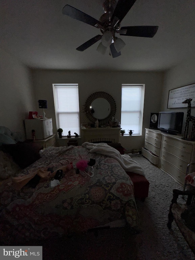 bedroom featuring carpet flooring, a ceiling fan, and multiple windows