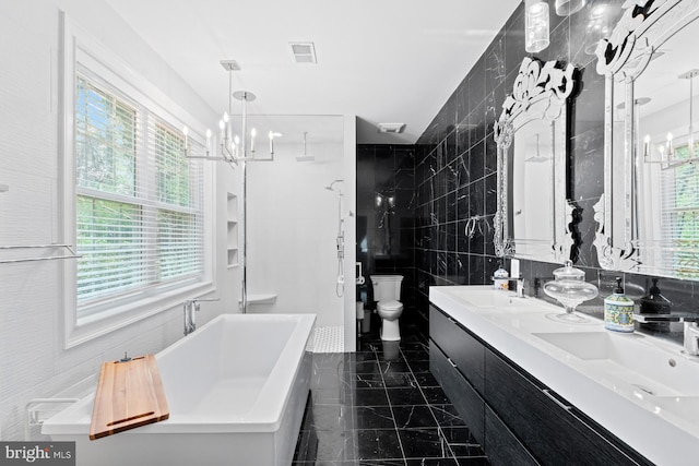 bathroom with a sink, tile walls, a chandelier, and toilet