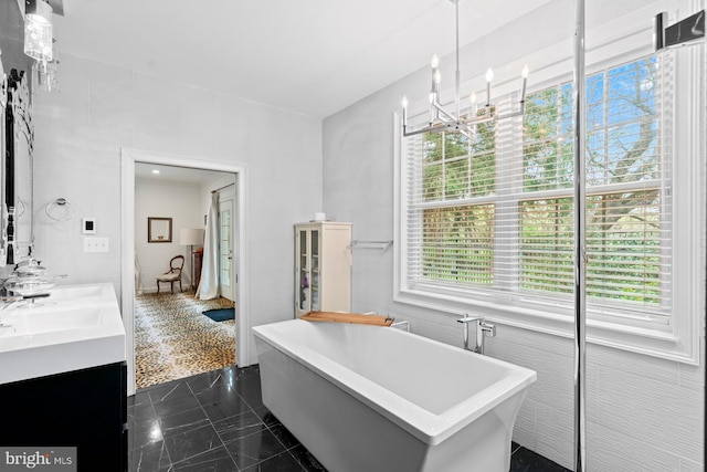 bathroom with a sink, a freestanding bath, and double vanity