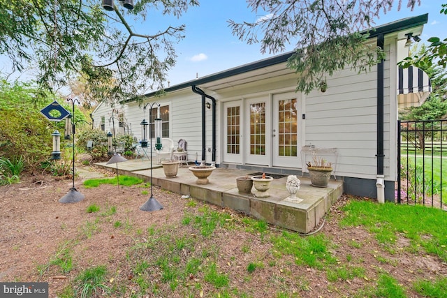 back of property with a patio area, french doors, fence, and an outdoor fire pit