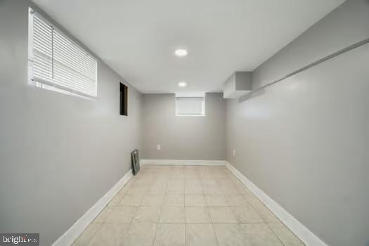 basement with recessed lighting, light tile patterned floors, and baseboards
