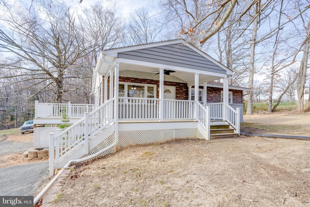 view of front of house featuring brick siding, a ceiling fan, and covered porch