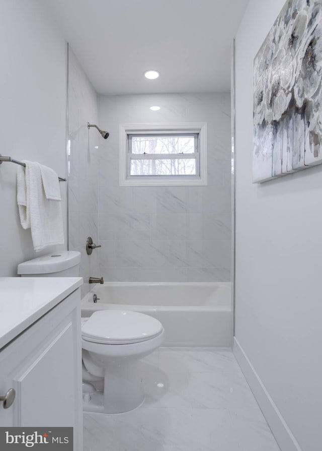 bathroom with baseboards, toilet, vanity, marble finish floor, and bathing tub / shower combination