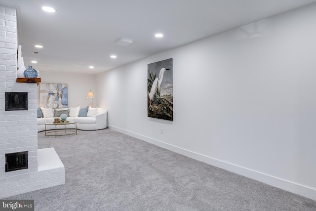 unfurnished living room with recessed lighting, a brick fireplace, and carpet floors