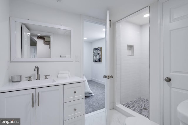 full bath featuring toilet, vanity, baseboards, and a stall shower