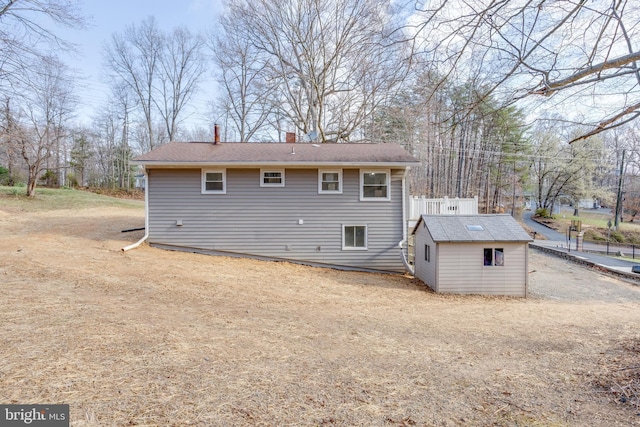 back of house with an outbuilding, a shed, and a chimney