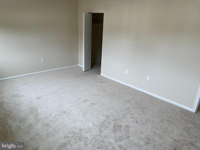carpeted empty room with baseboards
