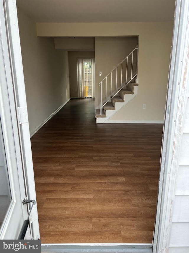 foyer featuring stairs, baseboards, and wood finished floors