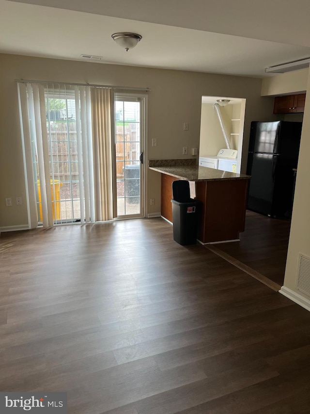 kitchen with visible vents, freestanding refrigerator, a peninsula, independent washer and dryer, and dark wood-type flooring