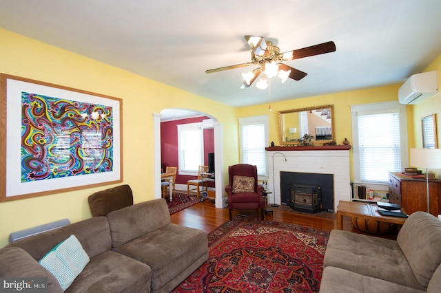 111 Somerset Ave, Cambridge, MD 21613 - living area with a ceiling fan, arched walkways, a wood stove, wood finished floors, and an AC wall unit