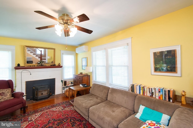111 Somerset Ave, Cambridge, MD 21613 - living room featuring a wall mounted air conditioner, ceiling fan, a wealth of natural light, and a wood stove