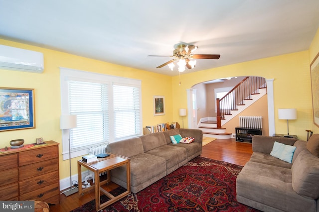 111 Somerset Ave, Cambridge, MD 21613 - living area featuring wood finished floors, stairway, arched walkways, a wall mounted AC, and a ceiling fan