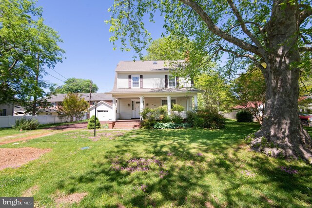111 Somerset Ave, Cambridge, MD 21613 - view of front of property with a porch, fence, an outbuilding, and a front lawn