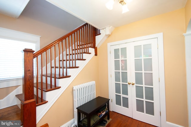 111 Somerset Ave, Cambridge, MD 21613 - stairway with french doors, wood finished floors, and radiator