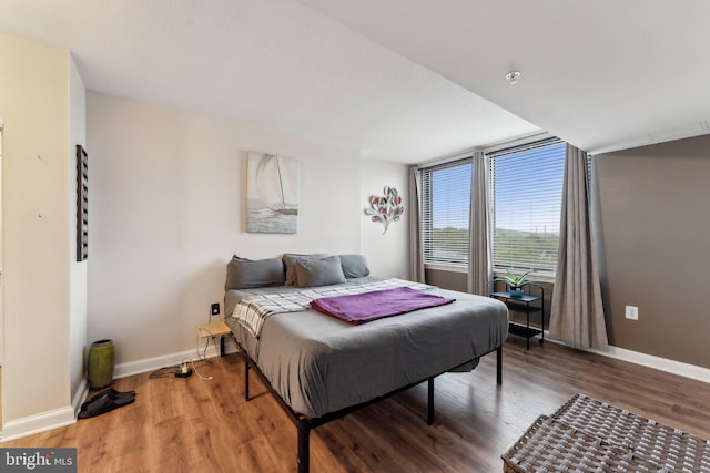 bedroom featuring baseboards and wood finished floors