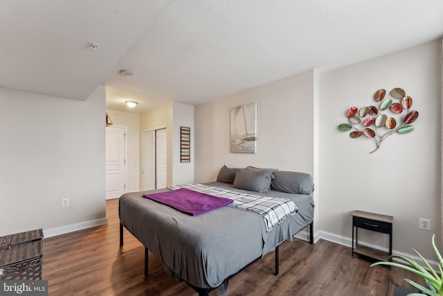 bedroom featuring a closet, baseboards, and wood finished floors