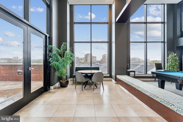 sunroom with french doors, a healthy amount of sunlight, a view of city, and pool table