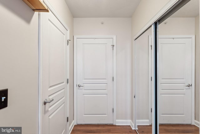 hall featuring baseboards and wood finished floors