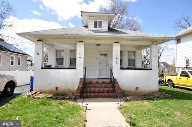 bungalow-style house with a porch, a shingled roof, and stucco siding