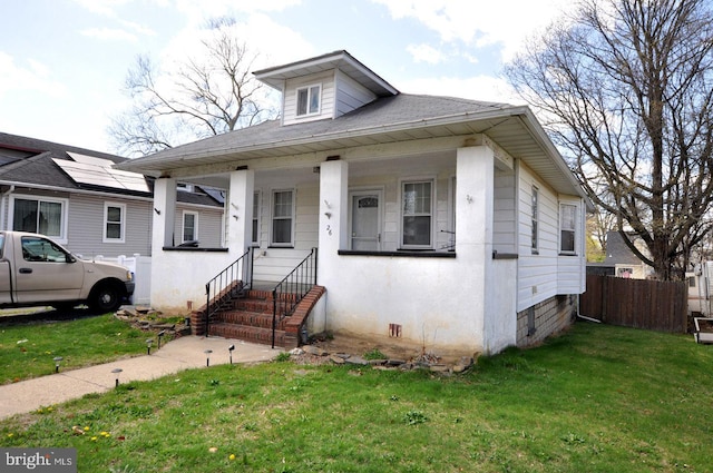 bungalow-style house with a front yard and fence