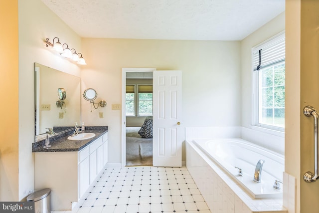 8900 Leonardo St, Pomfret, MD 20675 - bathroom with a garden tub, double vanity, a textured ceiling, and connected bathroom