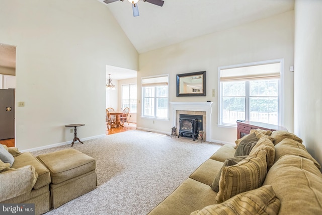 8900 Leonardo St, Pomfret, MD 20675 - carpeted living room with high vaulted ceiling, ceiling fan, a wood stove, a chandelier, and baseboards