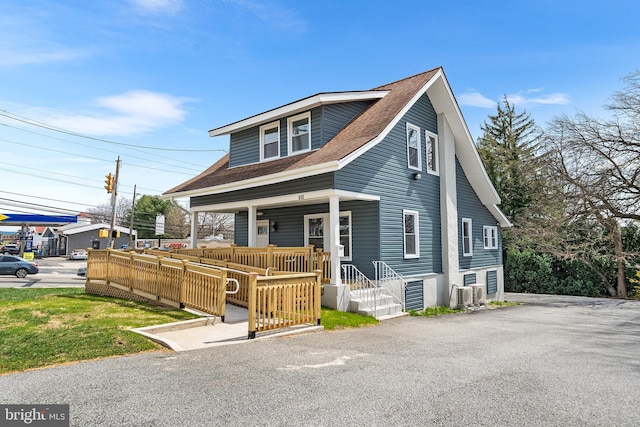 view of front of home featuring roof with shingles and covered porch